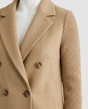 Manteau Sasha — détail du boutonnage et de la manche côtelée